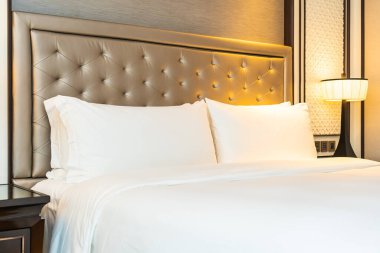 Yatak odasının iç dekorasyonuna beyaz yastık ve battaniye.