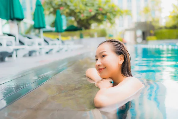 ポートレート美しい若いアジアの女性リゾートで屋外スイミングプールの周り幸せな笑顔のレジャーをリラックス — ストック写真