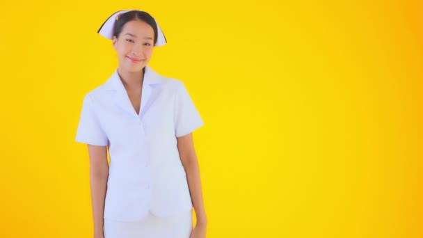 黄色に隔離された美しい若いアジア人医師のクローズアップ映像 — ストック動画