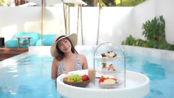 亚洲年轻貌美的女子在酒店度假胜地的游泳池边悠闲自在 — 图库视频影像