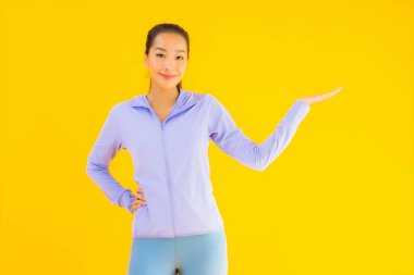 Sarı izole edilmiş arka planda spor giysili güzel Asyalı kadın portresi egzersize hazır.