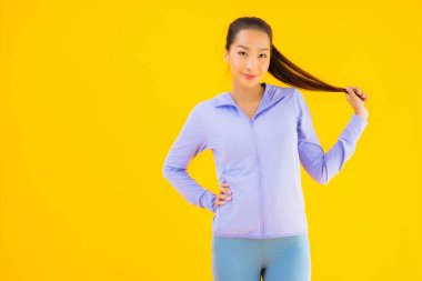 Sarı izole edilmiş arka planda spor giysili güzel Asyalı kadın portresi egzersize hazır.