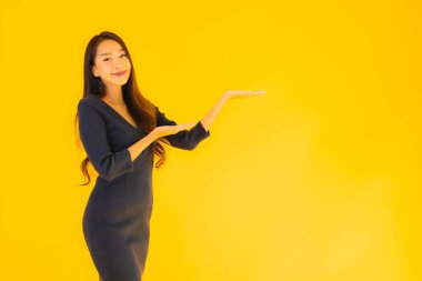 İzole edilmiş sarı arka planda hareketli güzel Asyalı kadın portresi.