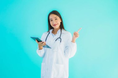 Steteskoplu ve akıllı tabletli güzel Asyalı doktor kadının portresi mavi arka planda hastane ve klinikte kullanılacak.