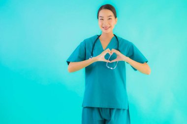 Güzel bir Asyalı genç doktor portresi. Mutlu bir gülümseme. Hastane ve klinikte çalışmak için kalp şeklini göster.