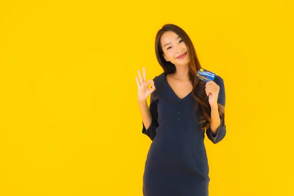 Portret Pięknej Młodej Azjatyckiej Kobiety Kartą Kredytową Żółtym Odizolowanym Tle — Zdjęcie stockowe