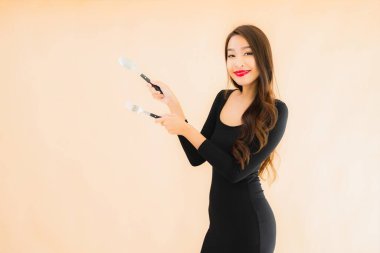 Kaşığı ve çatalı olan güzel Asyalı bir kadının portresi izole edilmiş renkli arka planda yemeye hazır.