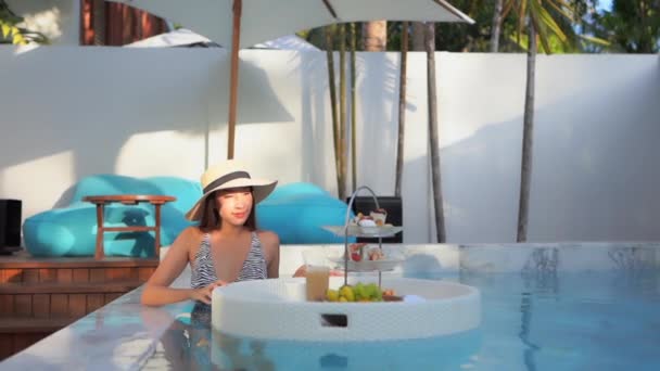 在酒店度假胜地 年轻的亚洲女子在游泳池周围悠闲自在 — 图库视频影像