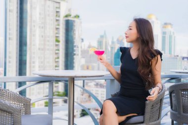 Güzel bir Asyalı kadın portresi. Kokteyllerle eğleniyor. Barda ve restoranda bardak içiyor.