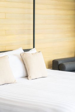 Otel odasındaki yatak odasının iç dekorasyonunda beyaz rahat yastık.