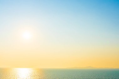 Güzel gün batımı ya da deniz kıyısı etrafında gün doğumu. Boş zamanlarında gökyüzünde bulut var.