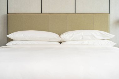 Yatak odasının içi beyaz, rahat yastık ve battaniye dekorasyonu.