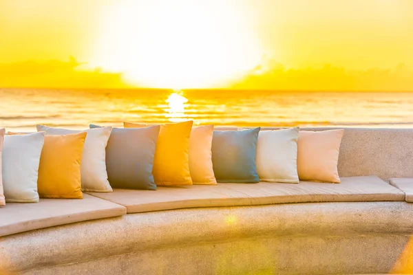Comfortable pillow on sofa chair around outdoor patio with sea ocean beach view for travel vacation at sunrise