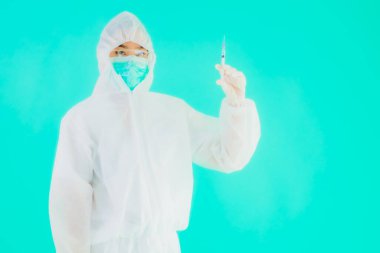 Portriat güzel genç Asyalı doktor kadın koronavirüsü korumak için şırınga aşısı ya da mavi arka planda kovid19