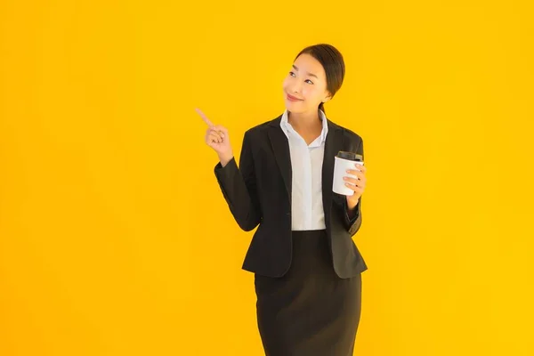 拥有智能手机和黄色独立背景咖啡杯的亚洲美女形象 — 图库照片