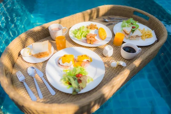 ホテルリゾートの屋外スイミングプールの周りに浮かぶ朝食 — ストック写真