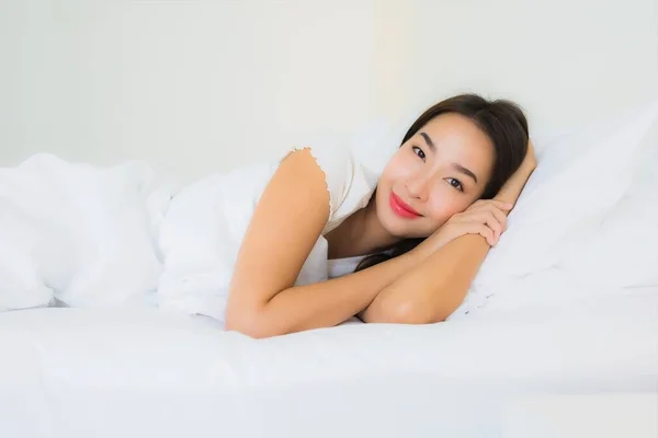 肖像画美しい若いアジアの女性リラックス幸せな笑顔でベッドの上に白い枕毛布インテリアのベッドルーム — ストック写真