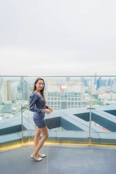 Portrait beautiful young asian woman happy smile on roof top restaurant around city view