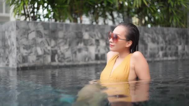 ホテルリゾートのプールでリラックスした若いアジアの女性の肖像画 — ストック動画