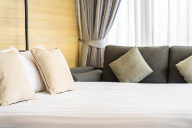 Otel odasındaki yatak odasının iç dekorasyonunda beyaz rahat yastık.