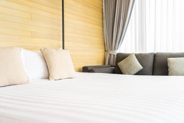Otel odasındaki yatak odasının iç dekorasyonunda beyaz rahat yastık.
