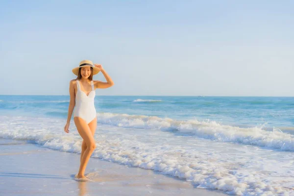 美丽动人的年轻亚洲女人快乐的笑着环抱着海滩和蓝天 享受休闲旅游之旅 — 图库照片