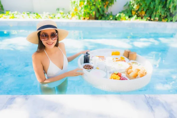 ポートレート美しい若いアジアの女性幸せな笑顔で浮遊朝食でトレイ上のスイミングプール — ストック写真