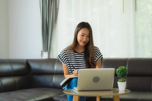 用笔记本电脑或电脑笔记本在沙发上刻画美丽的亚洲年轻女子形象 以避免头晕或惊慌失措 — 图库照片