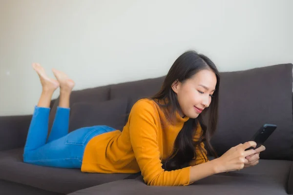 Portrett Ung Asiatisk Kvinne Som Bruker Smarttelefon Sofa Med Pute – stockfoto