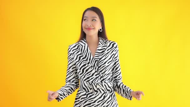 黄色に隔離されたゼブラスーツの美しい若いアジア人女性のクローズアップ映像 — ストック動画