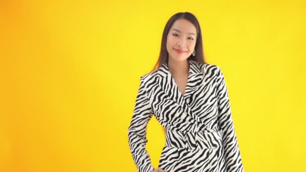 黄色に隔離されたゼブラスーツの美しい若いアジア人女性のクローズアップ映像 — ストック動画