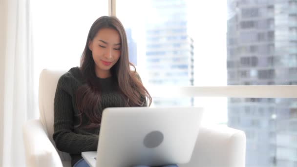 美丽的年轻亚洲女人在家里用笔记本电脑工作的镜头 — 图库视频影像