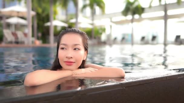 亚洲年轻貌美的女子度假时在宾馆的游泳池边悠闲自在地游玩 — 图库视频影像