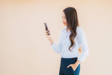 Akıllı cep telefonu ve kahve fincanı olan güzel bir iş kadını portresi.