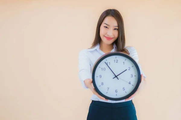 肖像美しい若いアジアの女性は 独立した色の背景に目覚まし時計を表示 — ストック写真