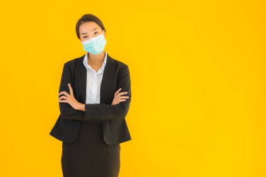 Güzel genç iş kadını portresi Korunmak için maske takıyor 19 koronavirüs sarı izole arka planda