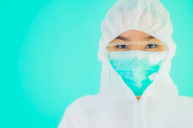 Güzel, genç Asyalı doktor kadın portre. Koronavirüsten ya da mavi arka planda kovid19 'dan korunmak için ppe ya da kişisel koruyucu ekipman takıyor.