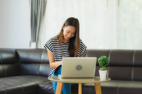 用笔记本电脑或电脑笔记本在沙发上刻画美丽的亚洲年轻女子形象 以避免头晕或惊慌失措 — 图库照片