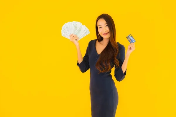 亚洲年轻貌美的女性形象 背景黄色 背景孤立 有现金和信用卡 — 图库照片