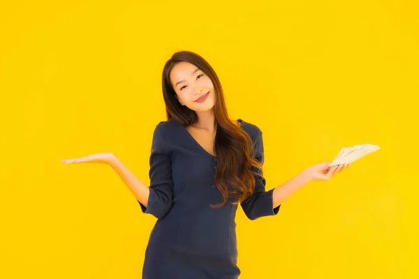 노란색 배경에 현금을 아름다운 아시아 여자의 — 스톡 사진