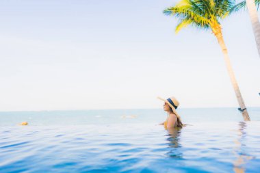 Güzel Asyalı genç kadınların portresi mutlu bir gülümseme otel tatil beldesinde yüzme havuzunda rahatlamak