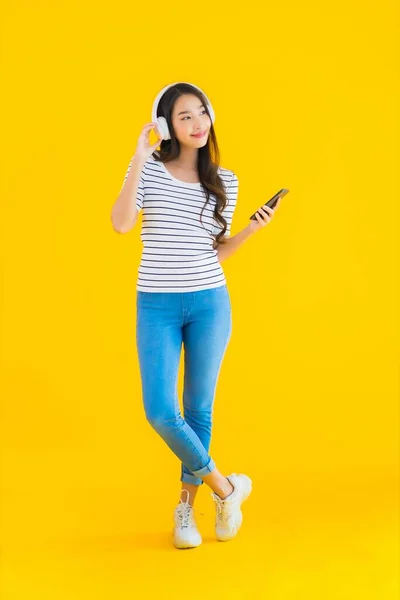 Portré Gyönyörű Fiatal Ázsiai Használ Okos Mobiltelefon Fejhallgató Hallgatni Zenét — Stock Fotó