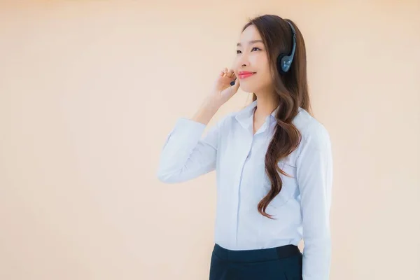 形象漂亮的年轻亚洲女商人 带着耳机 以独立的肤色背景为呼叫中心 — 图库照片