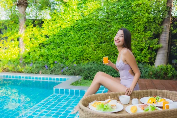ポートレート若いアジアの女性幸せな笑顔は ホテルのリゾートでプールで浮遊朝食トレイでお楽しみください — ストック写真
