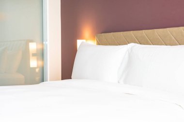 Yatak odasının iç dekorasyonu üzerine beyaz renkli rahat yastık ve battaniye.