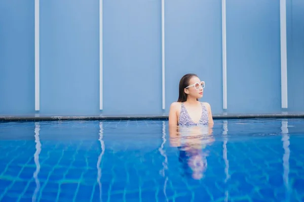 亚洲年轻貌美的女子在户外游泳池边悠闲地笑着度假 — 图库照片