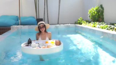 Güzel bir Asyalı kadın portresi. Mutlu bir gülümseme. Tatil için otel havuzunda rahatla.