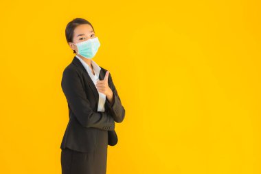 Güzel genç iş kadını portresi Korunmak için maske takıyor 19 koronavirüs sarı izole arka planda