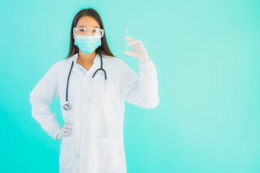 Aşı şırıngası ve kuraklığı olan güzel Asyalı doktor kadın portresi veya mavi arka planda hastane veya klinikte kullanılmak üzere ilaç şişesi.