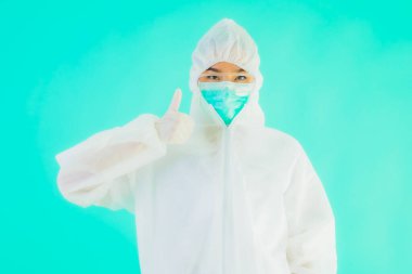 Güzel, genç Asyalı doktor kadın portre. Koronavirüsten ya da mavi arka planda kovid19 'dan korunmak için ppe ya da kişisel koruyucu ekipman takıyor.